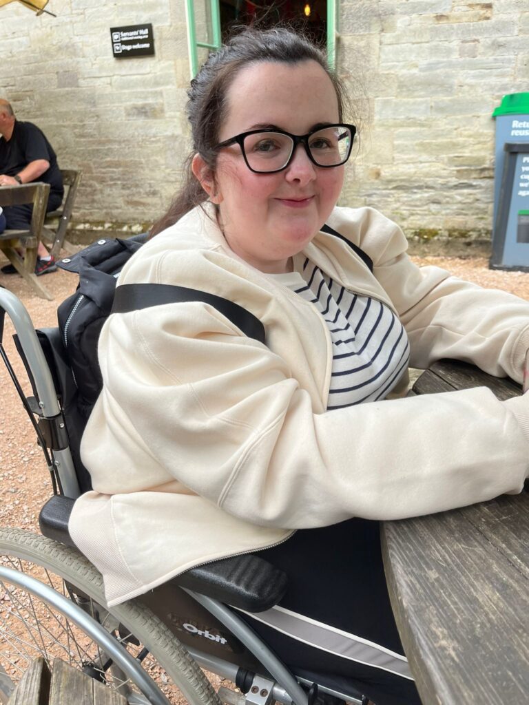 Tasmin sitting at a bench in her wheelchair

Tasmin lives with various rare conditions—APDS2 (activated phosphoinositide 3-kinase δ syndrome), postural orthostatic tachycardia syndrome, mast cell activation syndrome, oral allergy syndrome, histamine intolerance, aquaporin-4 antibody and MCADD (medium-chain acyl-CoA dehydrogenase deficiency). 