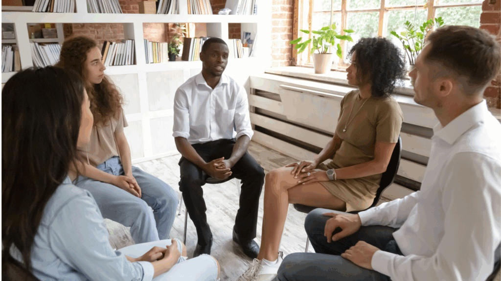 Image of a group of young people sitting in a circle in discussion