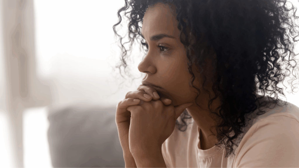 Image of a lady looking thoughtful to denote the impact a rare disease can have on daily life