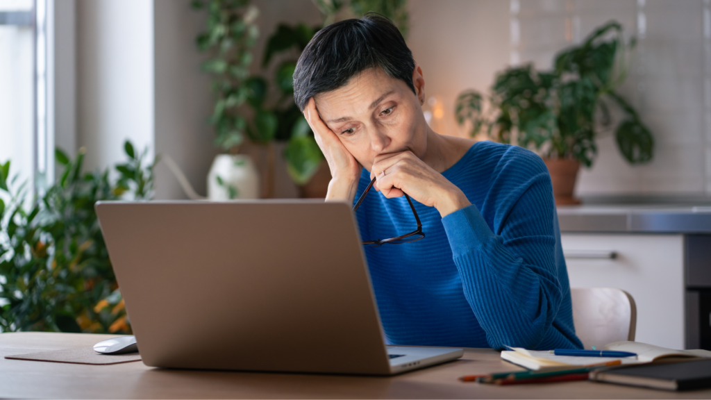 Image of a frustrated lady working from home looking at her laptop