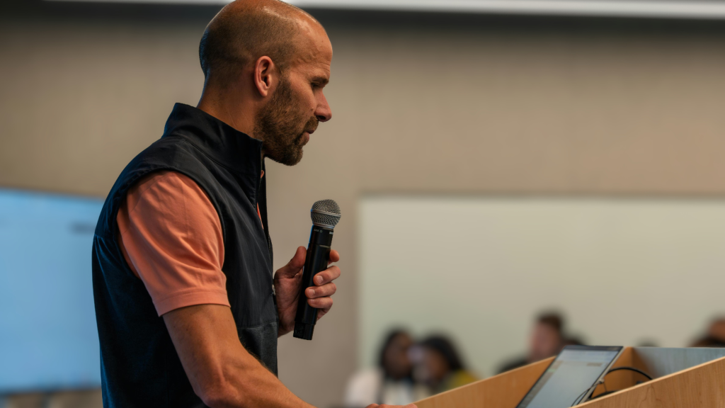 Photo of a man speaking into a microphone