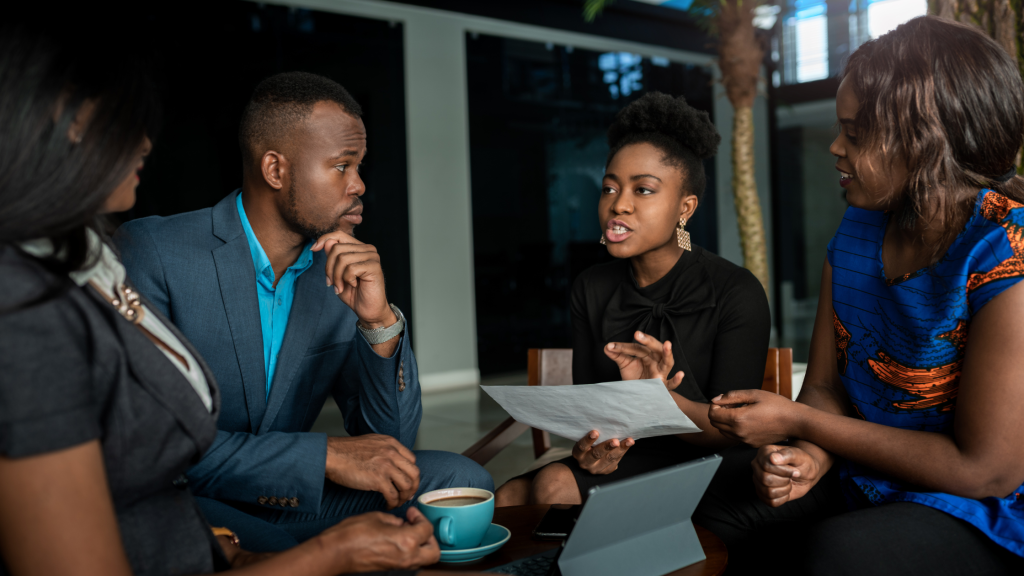 Image of four African people discussing business