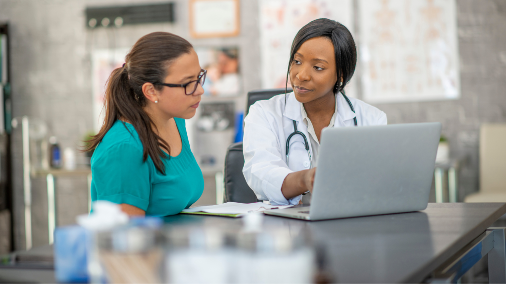 Photo of a doctor showing a patient something on a laptop