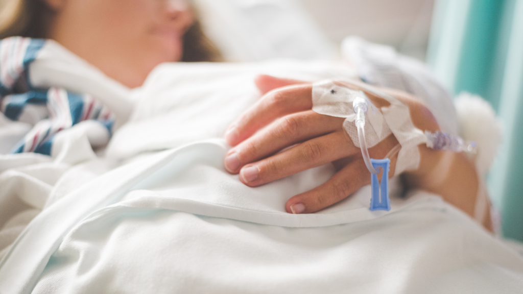 Photo of someone in a hospital bed with a cannula
