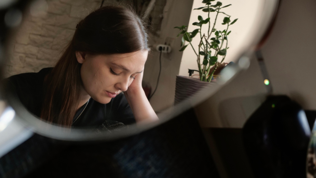 Photo of a lady in a mirror looking downcast