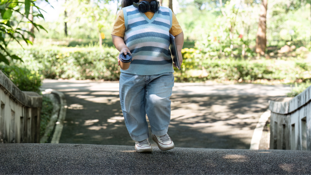 Photo of someone with achondroplasia walking through a park