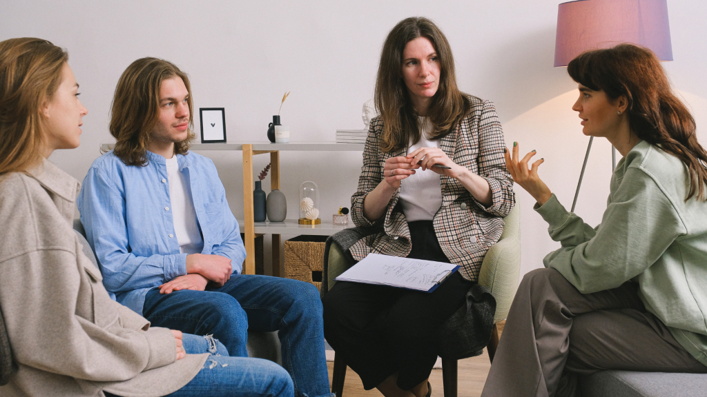 Photo of people talking while a professional takes notes, to denote the importance of patient engagement.