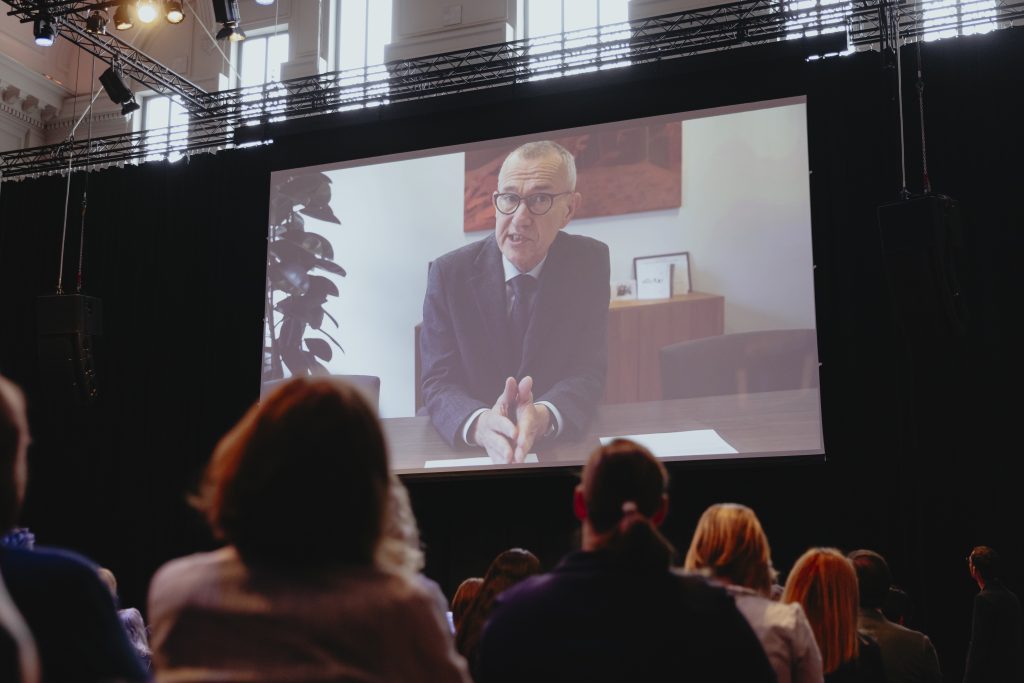 Photo of Belgium Health Minister, Frank Vandenbroucke, speaking at the conference via video link.
