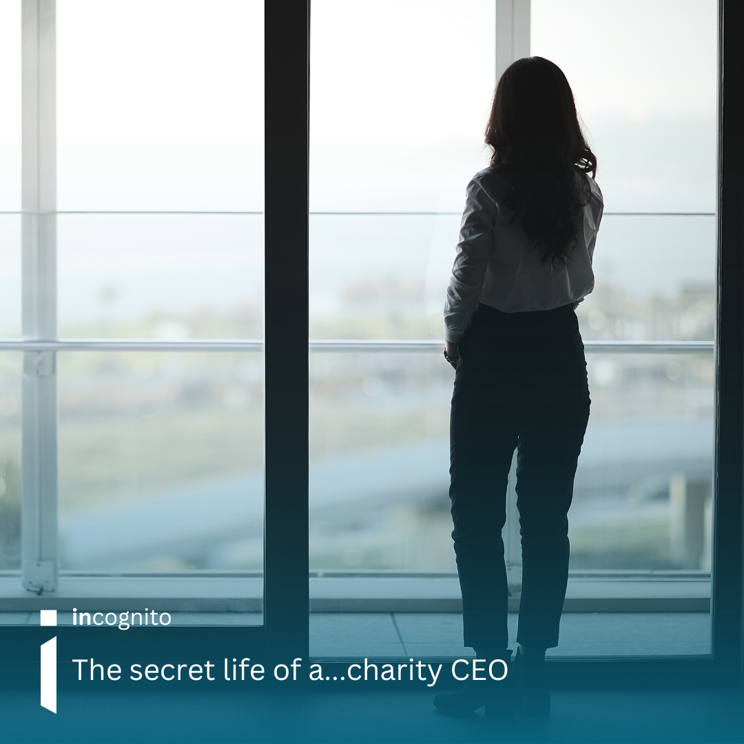 Photo of a professional woman standing looking out a window.