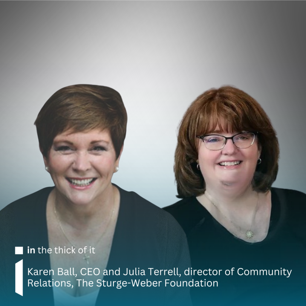 Image is of Karen Bll on the left smiling into the camera, wearing a black top and pearl earrings. She has short brown hair. On the right is Julia Terrell, smiling into the camera, wearing a black top, glasses and hoop earrings. She has longer than shoulder length brown hair. The background is grey/white.