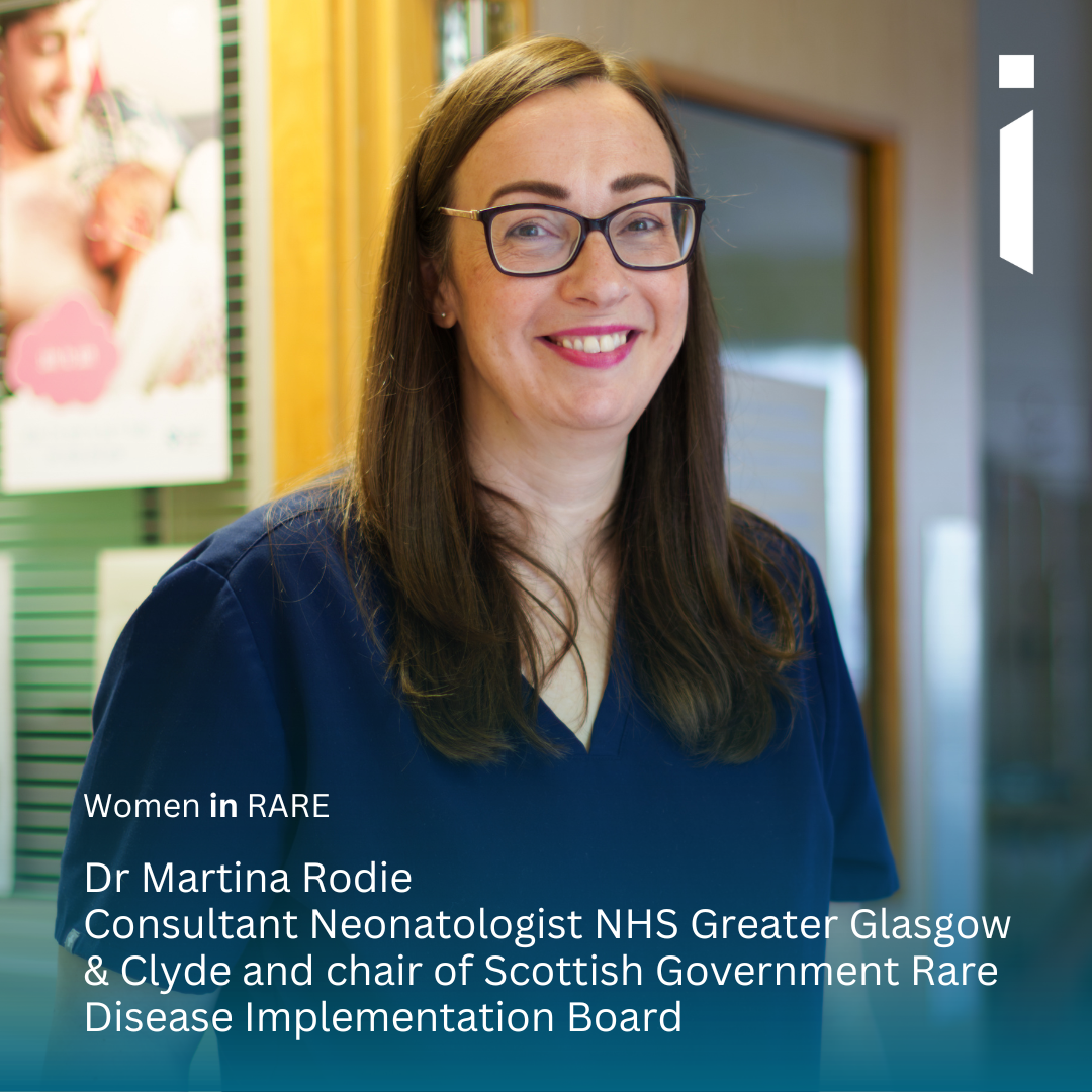 Headshot image of Dr Martina Rodie looking into the camera smiling. She has long brown hair and is wearing hospital scrubs. The background is a hospital.