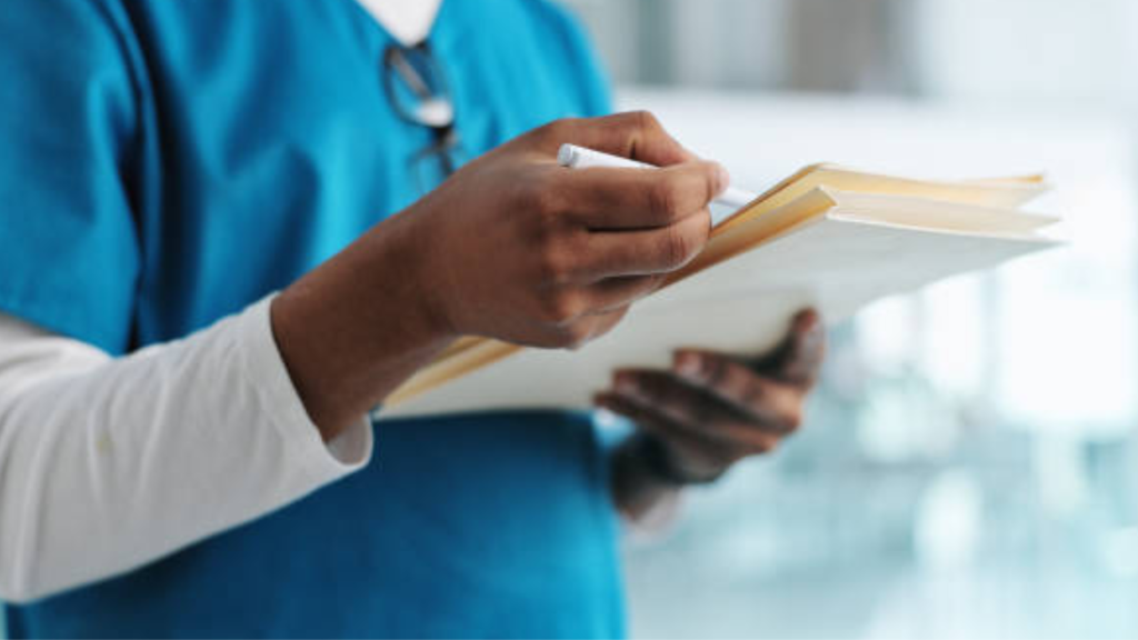 Image of a medical professional reading a patients records and charts
