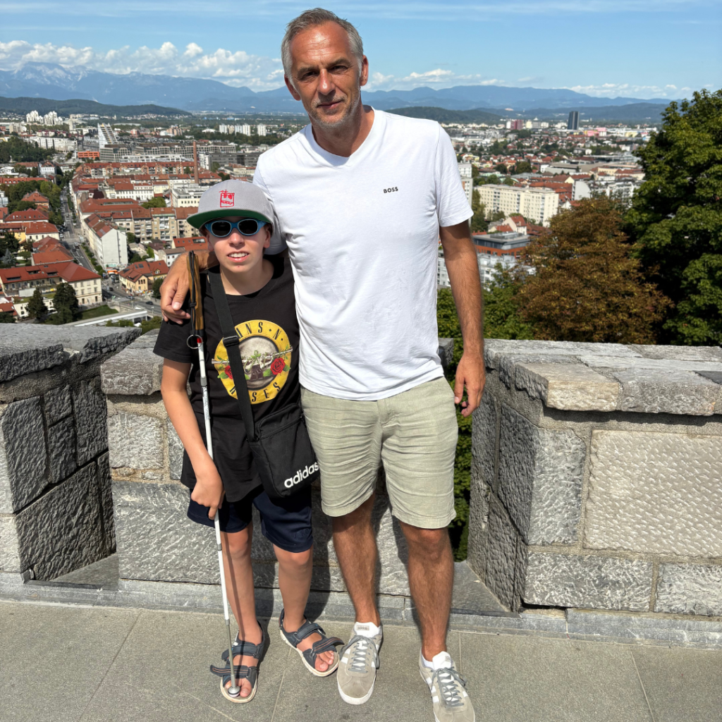 Inage of Bernd Rosenbichler and his son, Ben hugging and looking into the camera