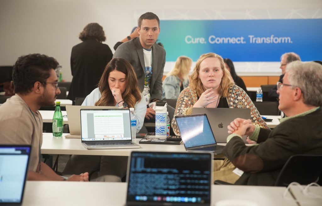 Photo of participants working at the Undiagnosed Hackathon