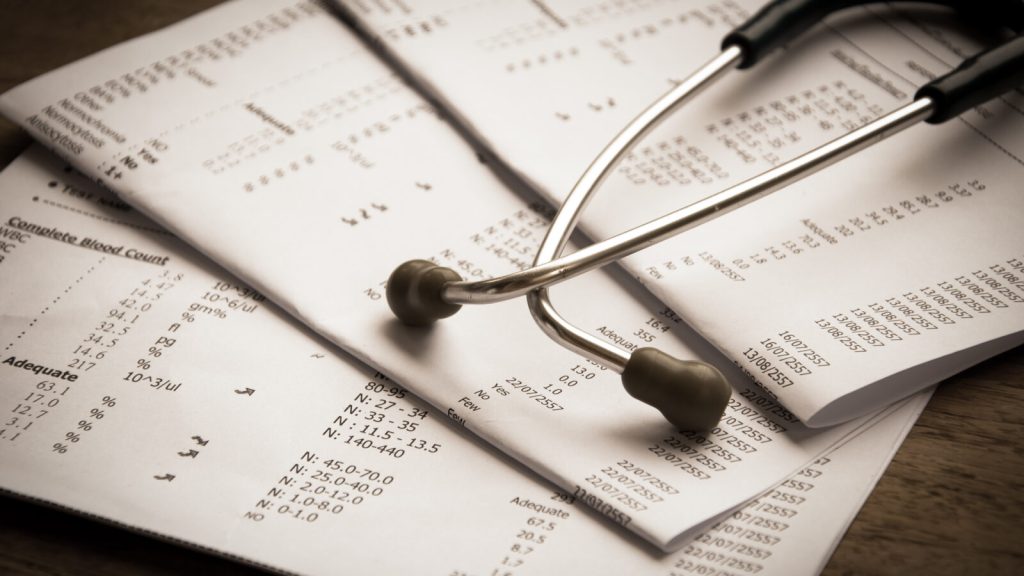 Image of a stethoscope on top of medical test results
