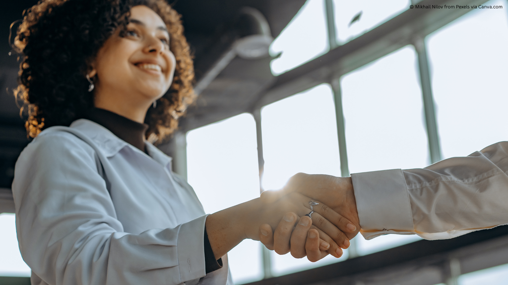 Image of a young person shaking hands with another person