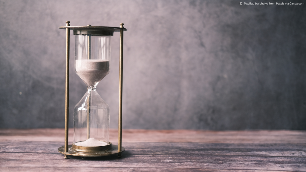 Image of a sand timer with smokey grey background